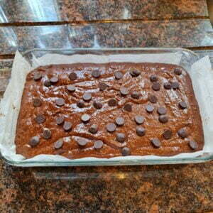 brownie mixture with the extra pieces of chocolate ready to go in the oven