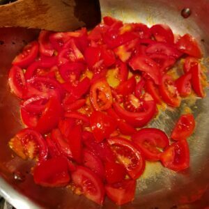 sauteeing the sliced tomatoes in olive oil