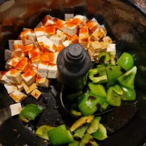 Sauteeing some peppers and tofu with chilli sauce and soy sauce