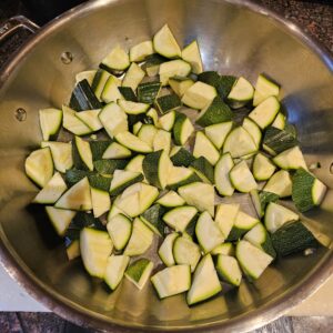 Adding the courgettes to the pan